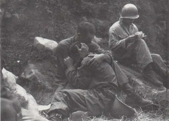 Αυτή η φωτογραφία δημοσιεύτηκε κατά τους πρώτους μήνες του πολέμου της Κορέας. Ο στρατιώτης κλαίει επειδή έχασε έναν σύντροφο. Ένας άλλος, πίσω, καταγράφει τις απώλειες.