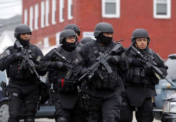 SWAT teams enter a suburban neighborhood to search an apartment for the remaining suspect in the Boston Marathon bombings in Watertown